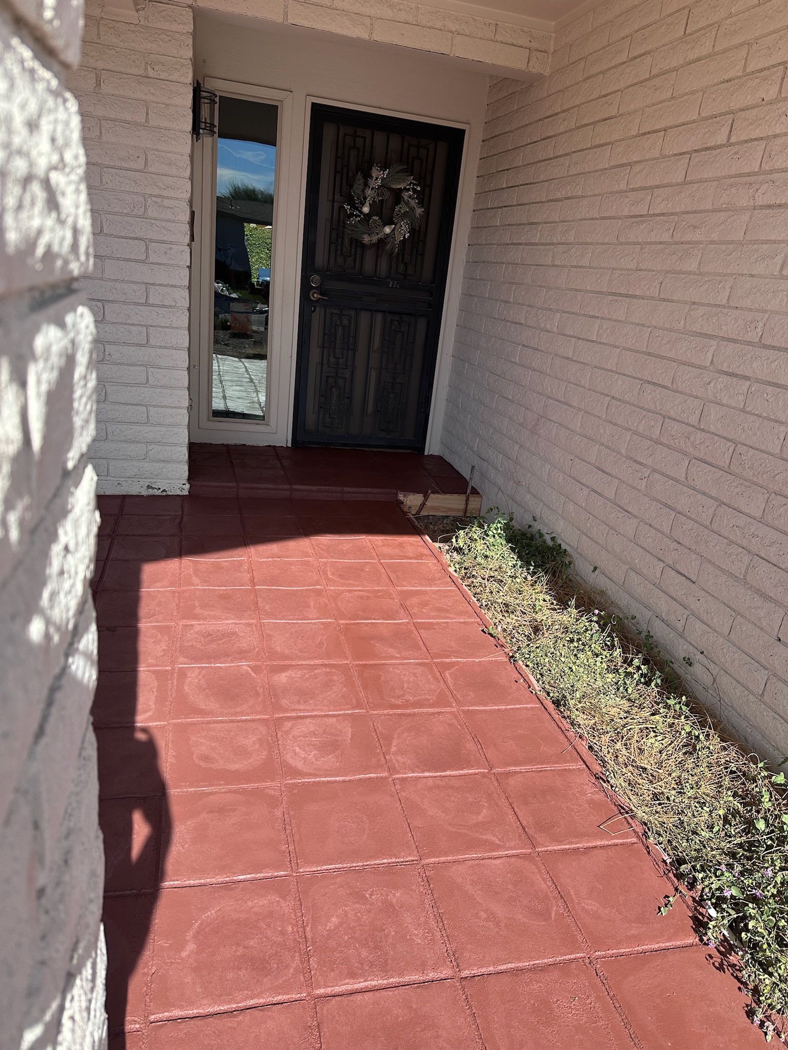 Terracotta-colored stamped concrete entryway leading to a residential front door