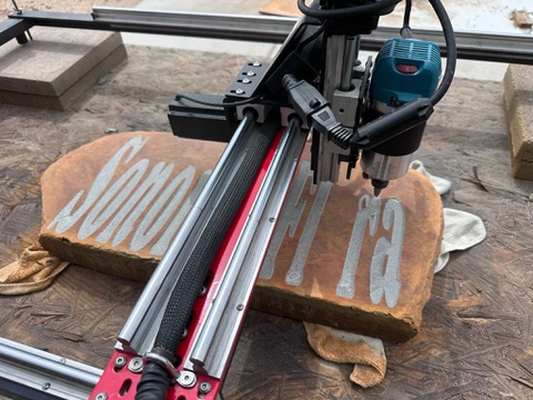 Precision engraving machine cutting Sonoran Flora lettering into the custom garden stone
